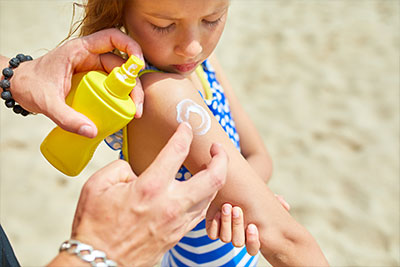 a child getting sun screen on their sholder